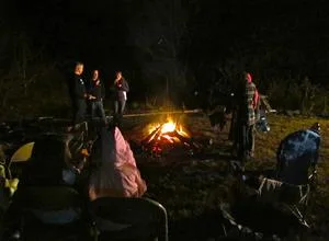 The bonfire glowing with families seated around it