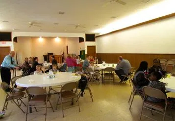 Families sharing a potluck lunch in the fellowship hall